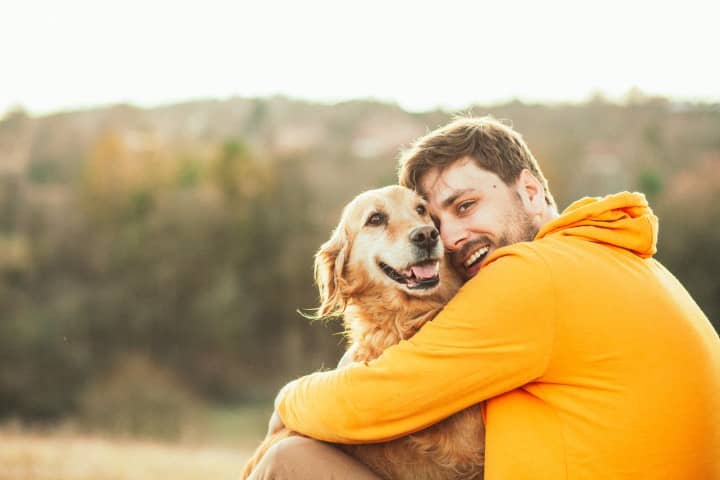 homme faisant un calin à son chien
